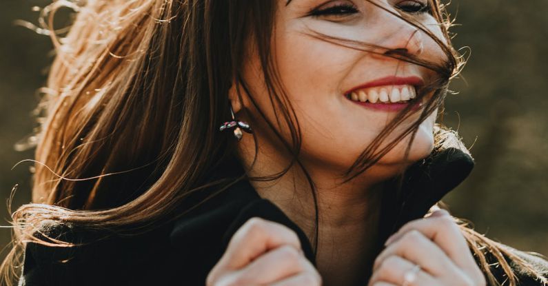 Bamboo Wind - A woman smiling and laughing while wearing a black coat