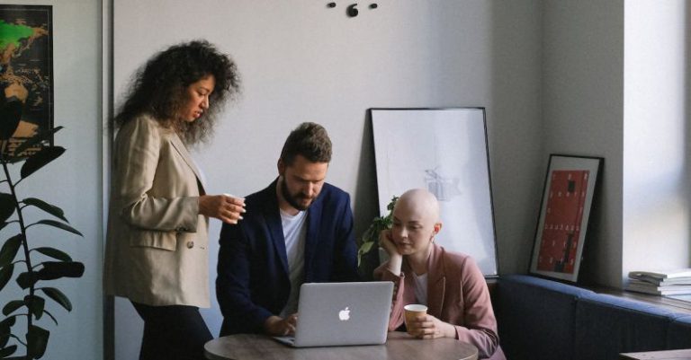 Clock Strategy - Diverse coworkers using laptop and speaking about job