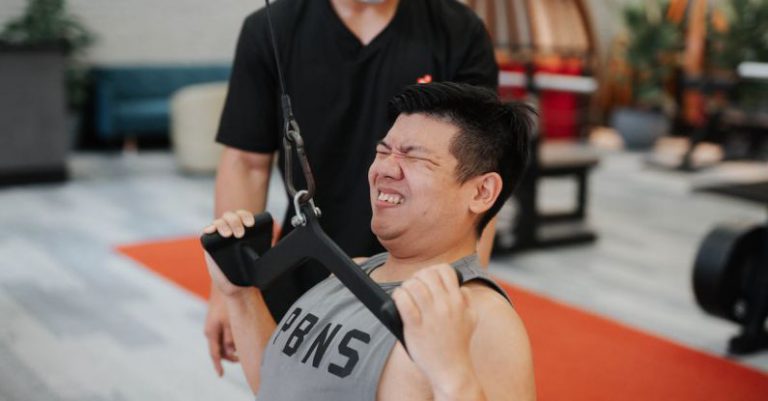 Effort Treasure - Close up of Young Man Doing Intense Exercises, being Guided by Personal Trainer