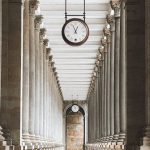 Clock Sprout - A long hallway with columns and a clock