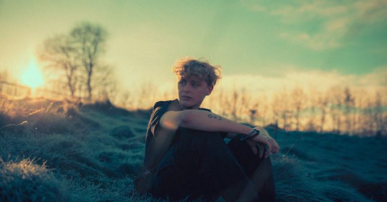 Chess Dawn - A young man sitting on top of a hill