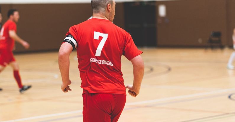 Keys Team - A man in red soccer uniform running with the ball